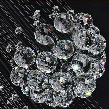 A decorbites™ modern crystal chandelier with 13 clear faceted spheres suspended by wires for high ceiling with led bulbs
