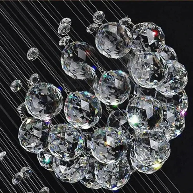A decorbites™ modern crystal chandelier with 13 clear faceted spheres suspended by wires for high ceiling with led bulbs