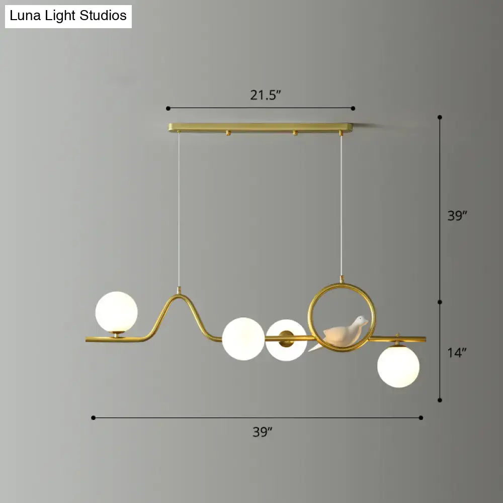 Gold-toned decorbites™ modern curve island ceiling light with curved metal frame and frosted glass spheres for dining room