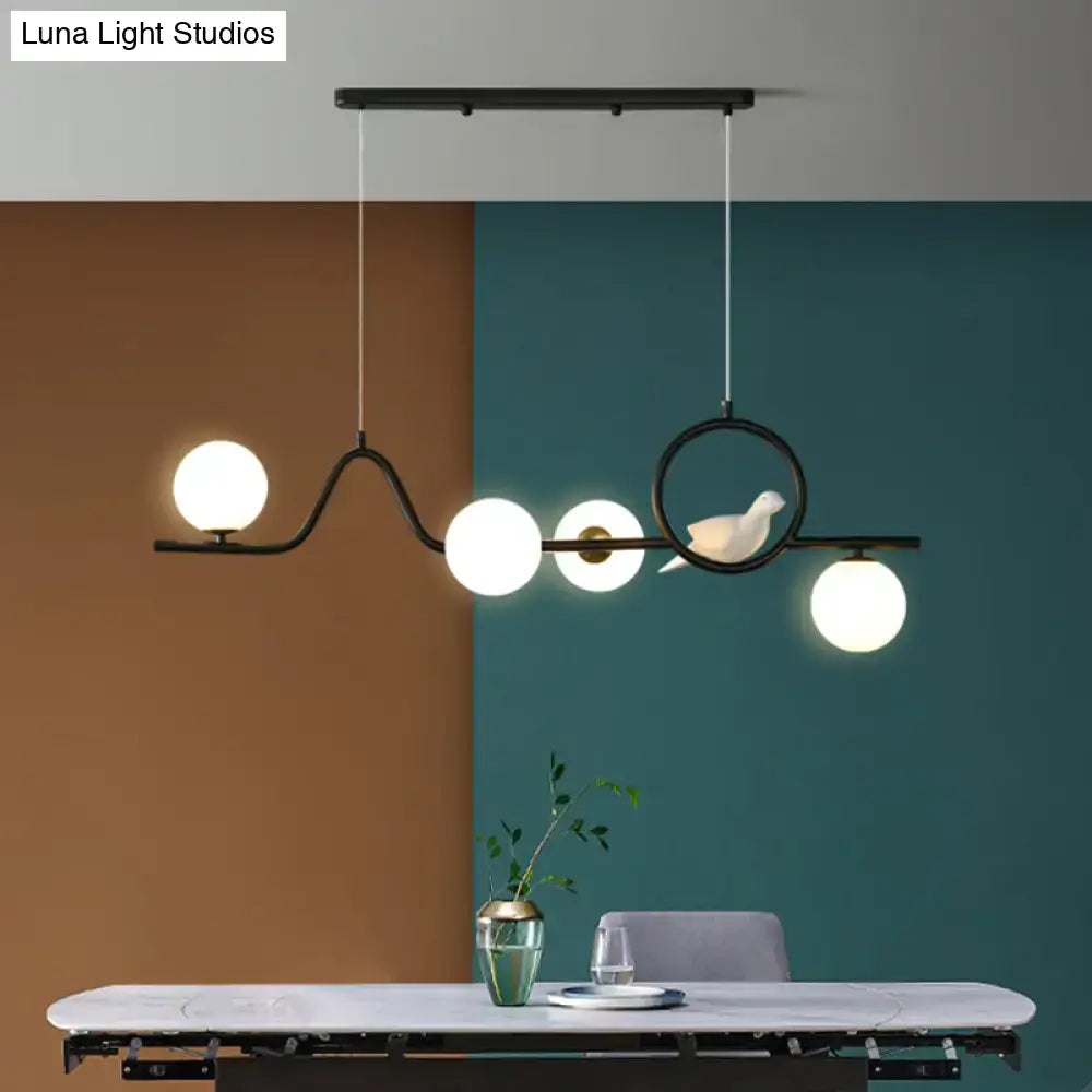 Black metal DecorBites™ modern curve island ceiling light with four frosted glass bulbs and white ceramic bird