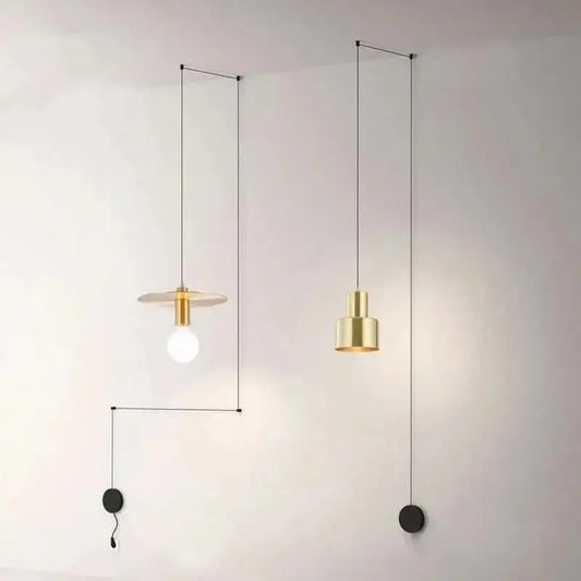 Two minimalist brass pendant lights with geometric designs hanging from black cords in decorbites™ modern diy pendant light