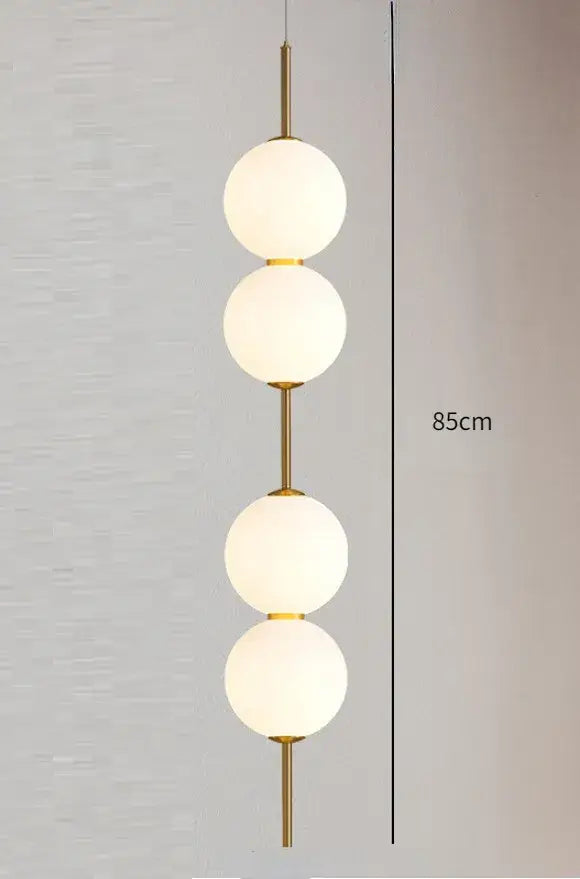 DecorBites™ modern glass pendant lighting with gold-toned frame and four frosted white spherical glass globes stacked vertically