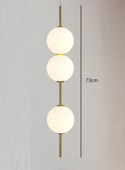 Decorbites™ modern glass pendant lighting featuring a gold-toned glass pendant with three frosted spheres stacked vertically