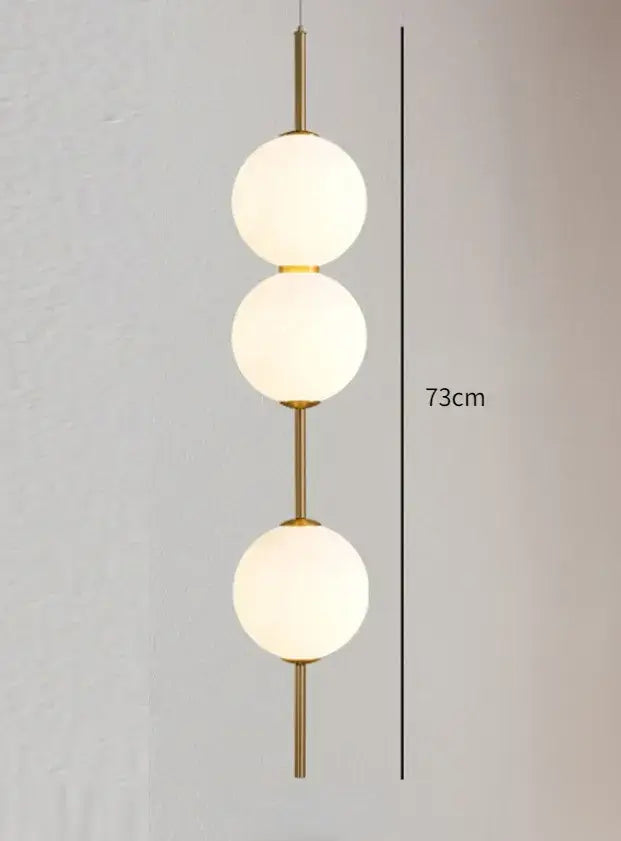 Decorbites™ modern glass pendant lighting featuring a gold-toned glass pendant with three frosted spheres stacked vertically