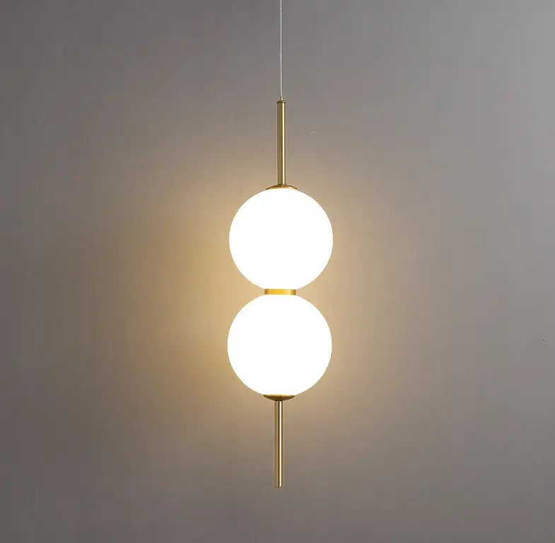 DecorBites modern glass pendant lighting with two frosted glass spheres suspended by a slender brass rod