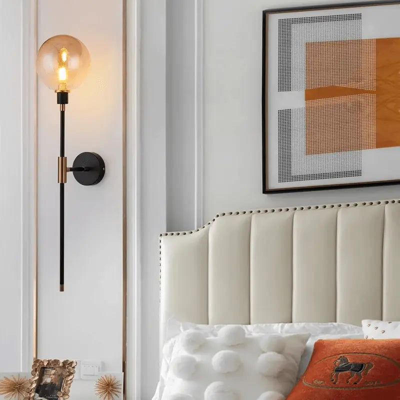 DecorBites modern glass wall sconce with warm amber globe and sleek black metal stem with gold hardware accents