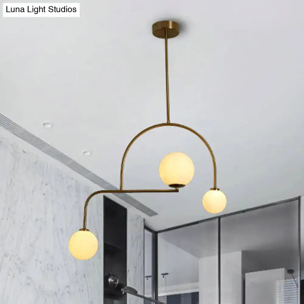 Modern brass pendant light with three yellow white frosted glass bulbs for modern global bedroom decor