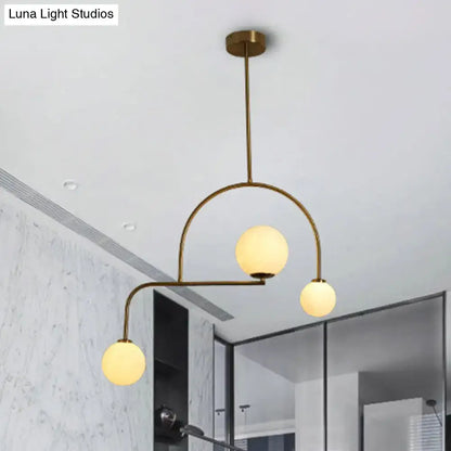 Modern brass pendant light with three yellow white frosted glass bulbs for modern global bedroom decor