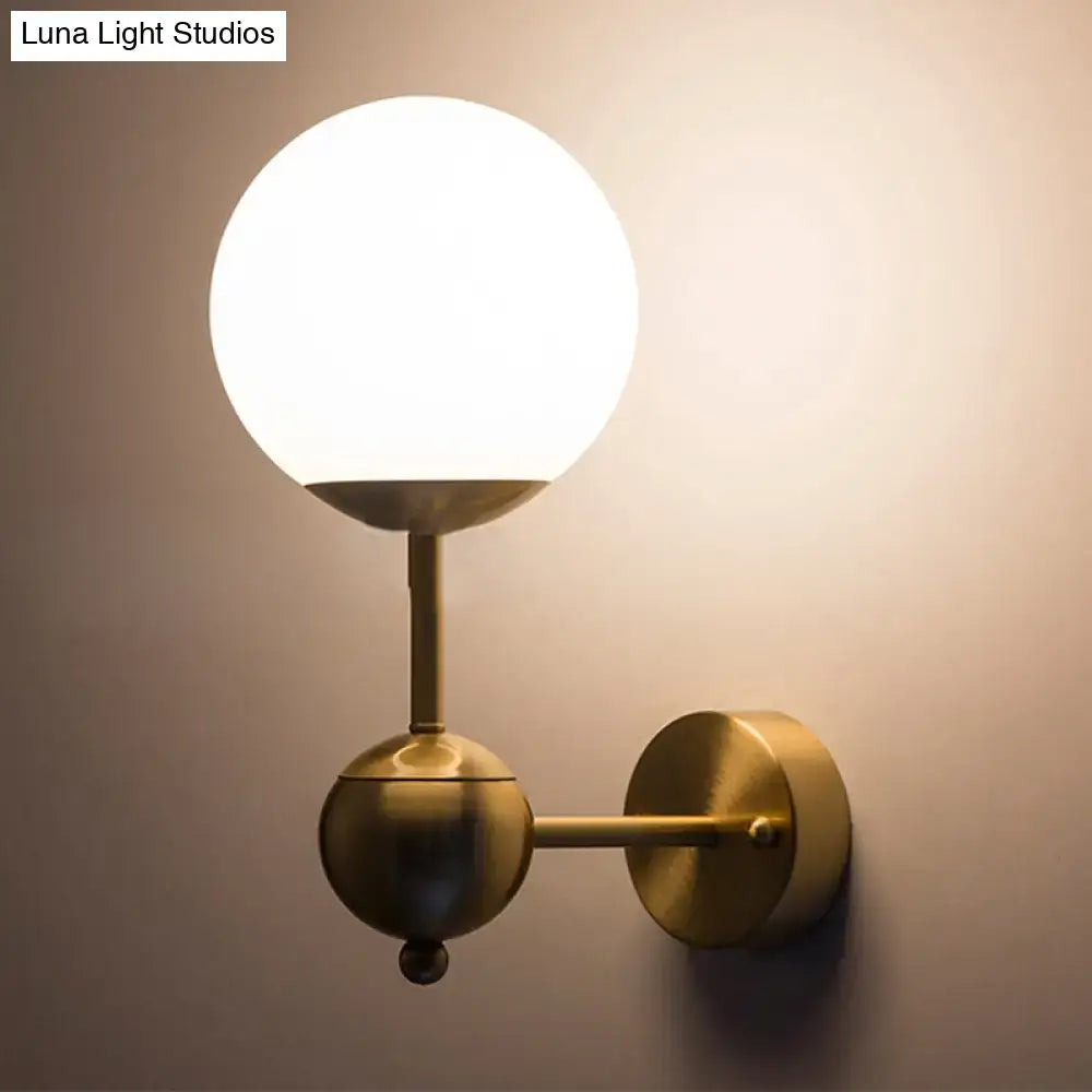 Modern brass and white glass globe sconce with matte white glass shade direct wired led light for bathroom use