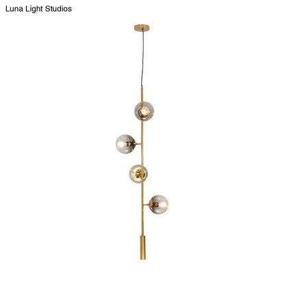 DecorBites modern gold linear chandelier with five frosted gray glass shades on a slender metal rod hanging fixture