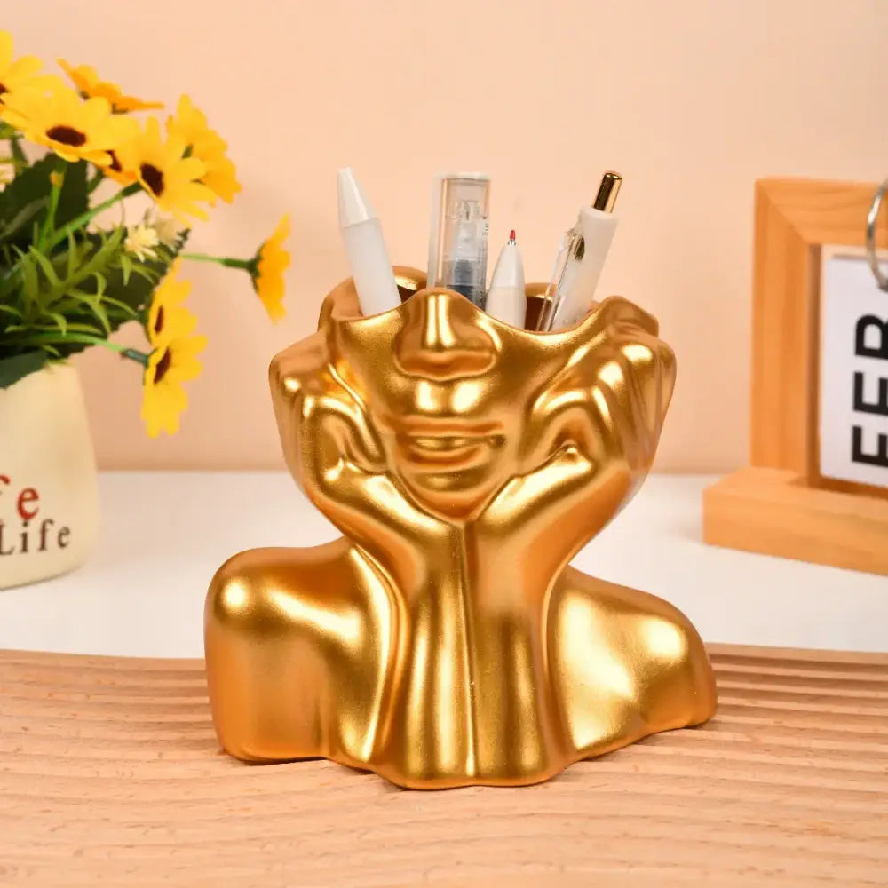 Golden glossy resin vase shaped like a smiling woman’s head with hands on cheeks for modern body shaping decor