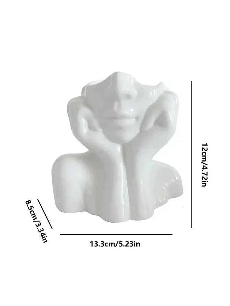 White ceramic human body resin vase shaped as a modern woman bust with hands resting on her cheeks by DecorBites™