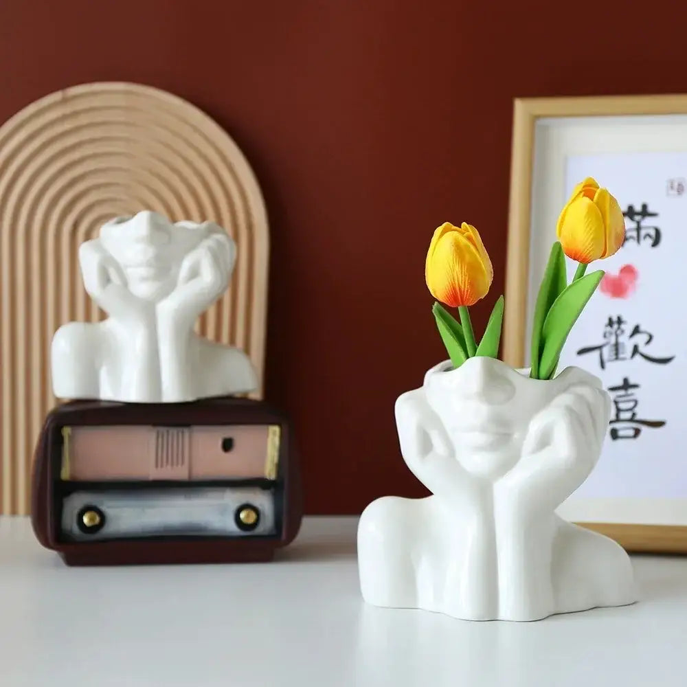 DecorBites™ modern white resin vase shaped like a human body head with hands holding yellow tulips for decor