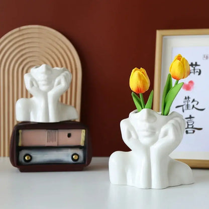 DecorBites™ modern white resin vase shaped like a human body head with hands holding yellow tulips for decor