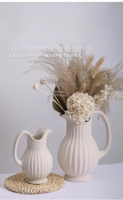 Cream-colored ins style ceramic spiral vase with vertical ribbed texture and handle filled with pampas grass and hydrangeas