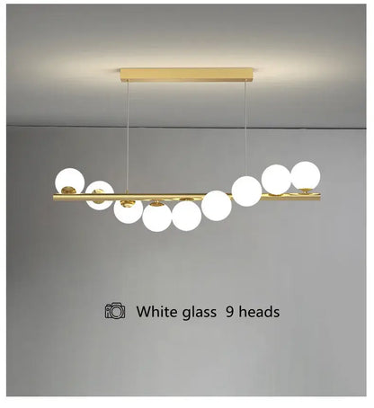 Gold-toned decorbites modern led glass chandelier with nine white glass bulbs on a horizontal bar for dining room use