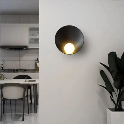 Black matte-finished decorbites modern led wall light with circular bowl-shaped design and warm illuminated bulb