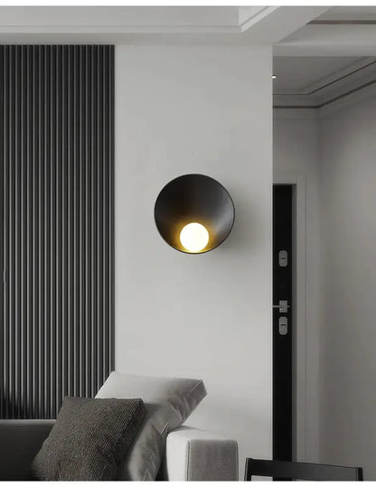 Black matte-finished decorbites™ modern led wall light with circular bowl-shaped design emitting warm light