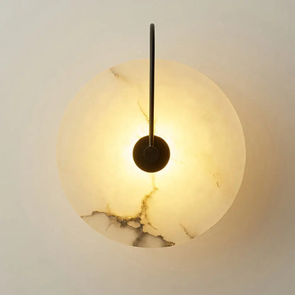 Warm-toned circular onyx marble wall lamp with sleek black metal arm from decorbites modern marble wall collection