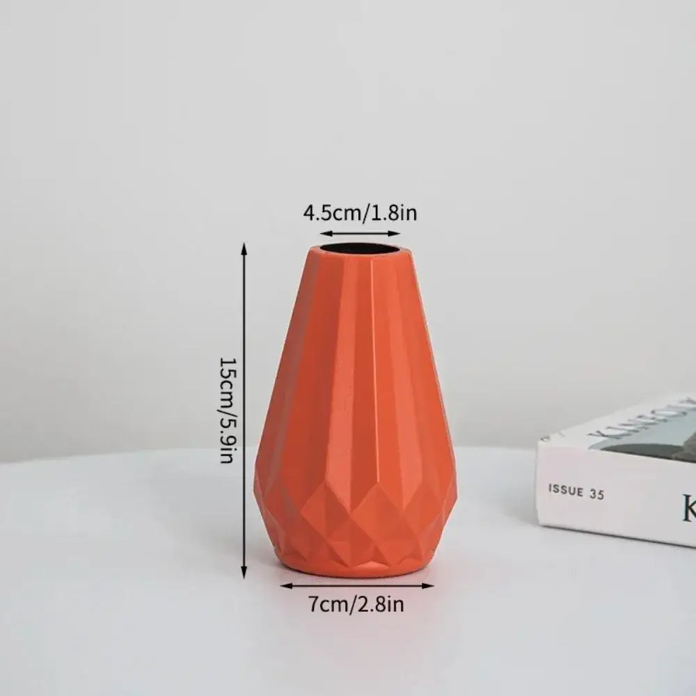 A vibrant orange ceramic flower vase with a diamond shaped faceted geometric design by DecorBites™ Modern Nordic