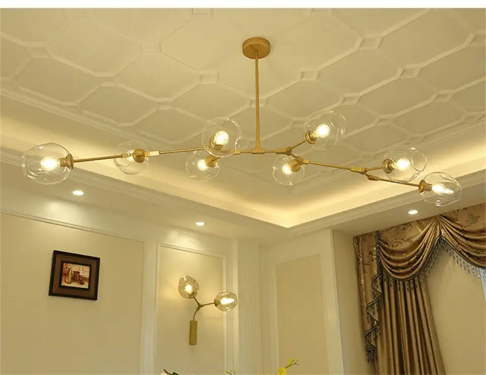 Gold-toned modern nordic glass chandelier with clear glass globe bulbs and branching metal design by DecorBites™