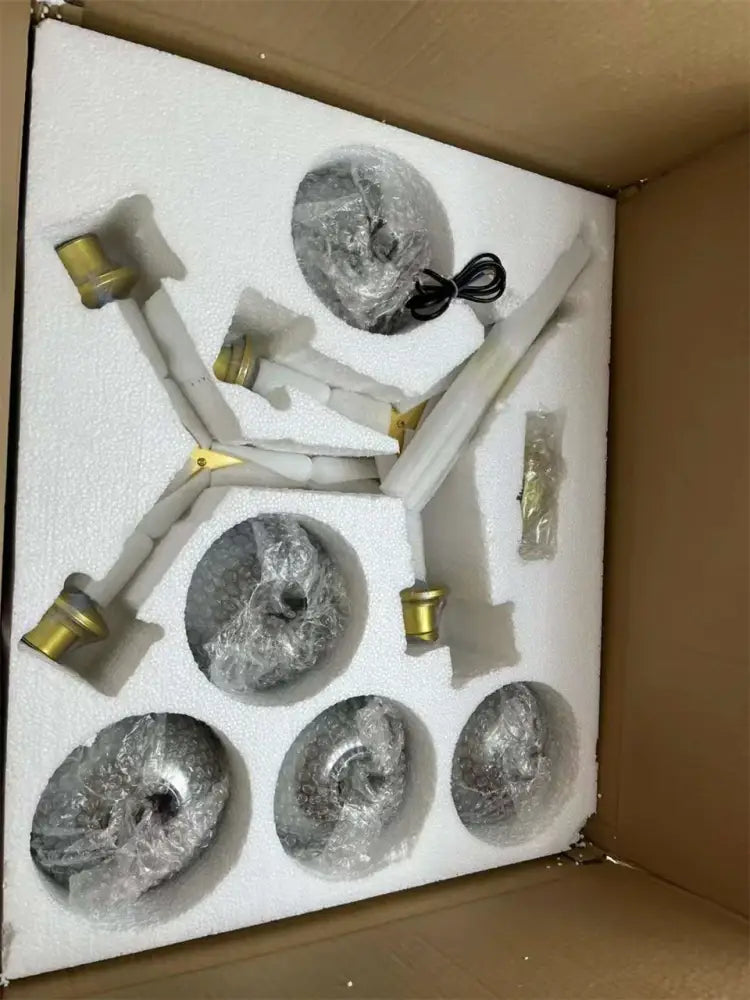 Set of five silver ammonite-shaped decorative objects with gold caps in foam packaging for modern nordic glass chandeliers