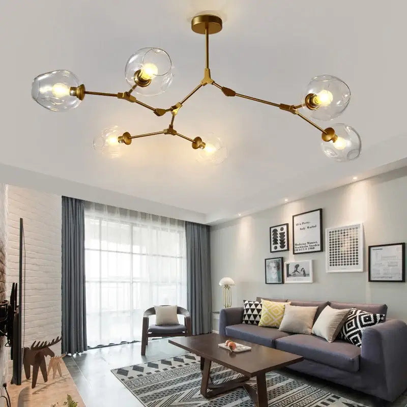 Gold-toned modern nordic glass chandelier with clear globe bulbs and a branching design by DecorBites™