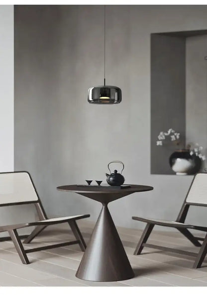 Dark bronze conical table paired with a modern nordic glass pendant lamp featuring a minimalist glass restaurant pendant design