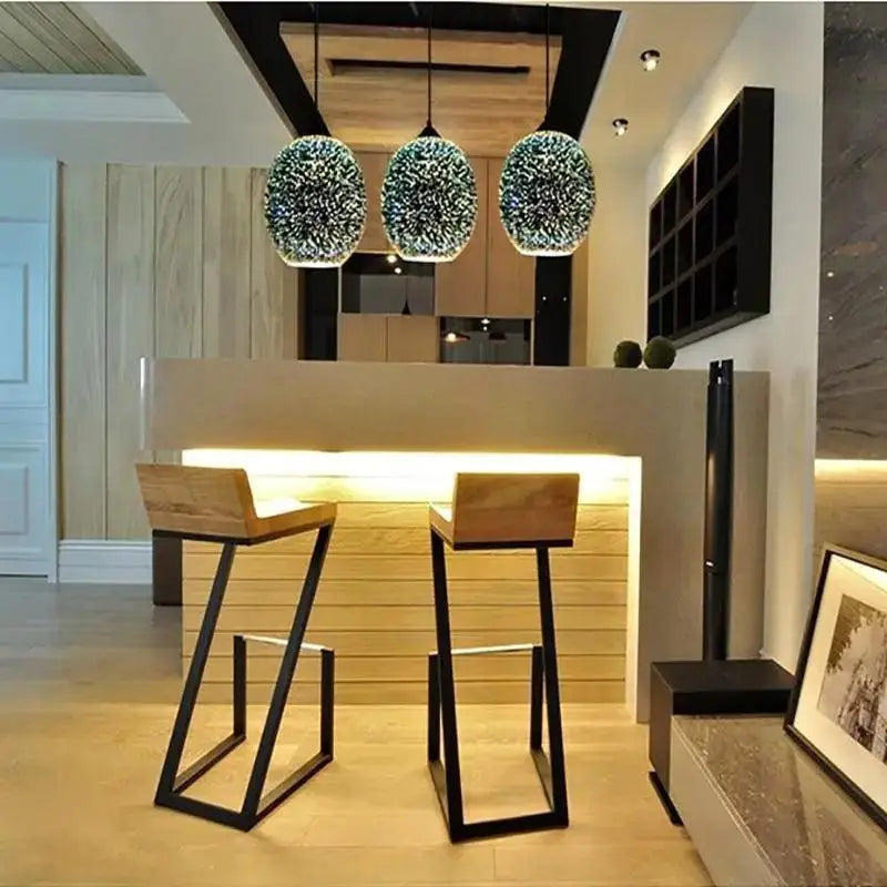 Three spherical glittering glass pendant lights hang above a modern nordic bar counter in DecorBites modern nordic pendant light