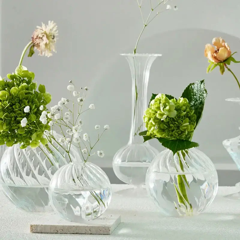 DecorBites modern Nordic glass vases set with clear textured ribbed surfaces holding green hydrangeas and white baby’s breath