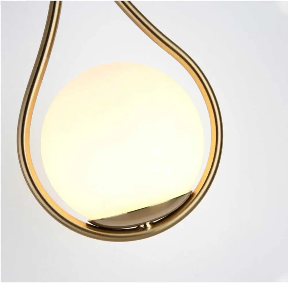 Decorbites modern nordic livi wall lamp with teardrop frosted glass globe and polished brass frame emitting warm glow