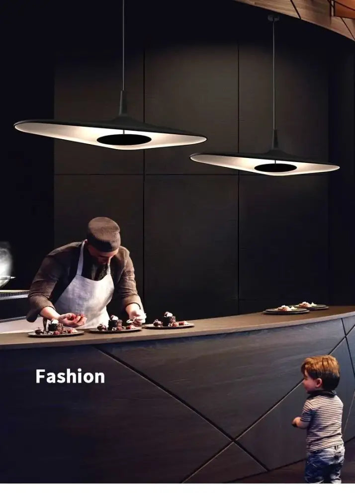 DecorBites™ modern black resin pendant lamp with changeable light features hangs above a dining room countertop