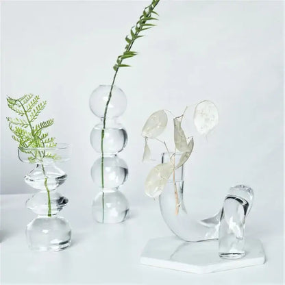 Decorbites™ modern transparent glass vases set with spherical and curved designs holding delicate greenery to decorate root