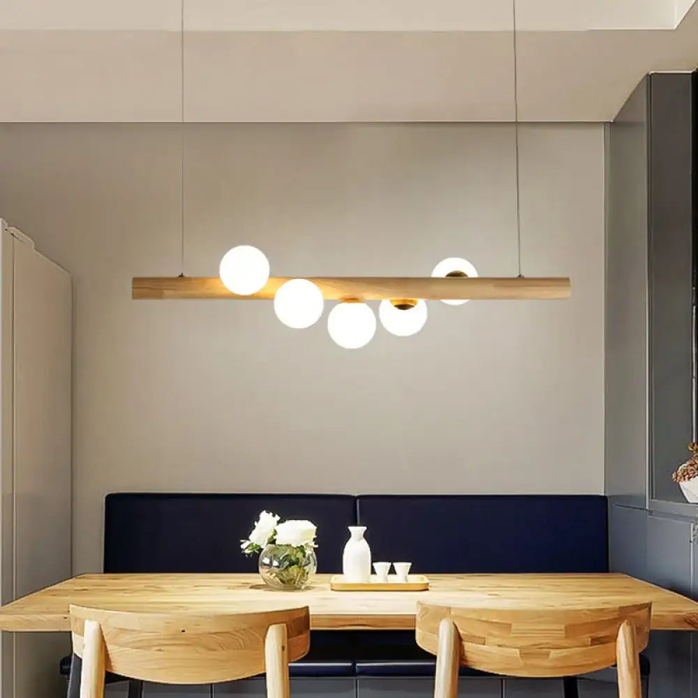 Decorbites modern wood stick pendant light kit with five beige frosted glass globes for dining room island lighting