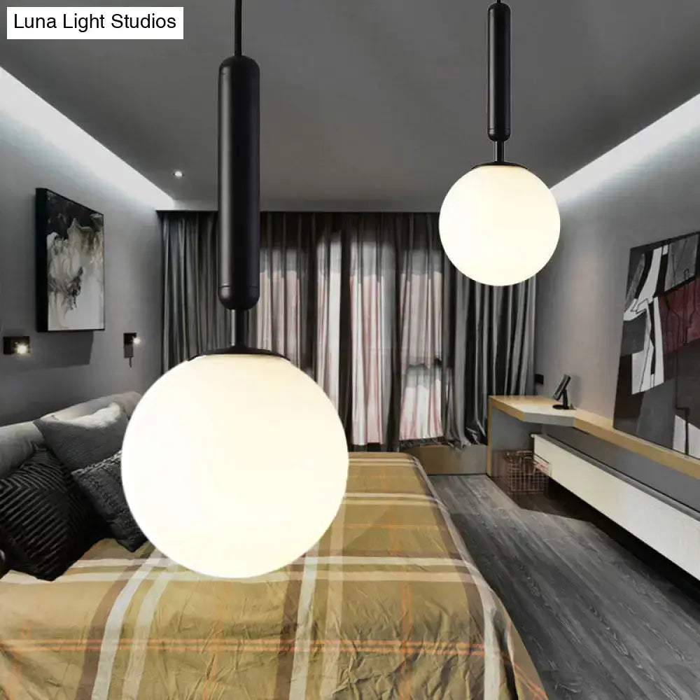 Decorbites™ modernist white glass pendant light with black and gold finish features black cylindrical fixtures with frosted shades above bed