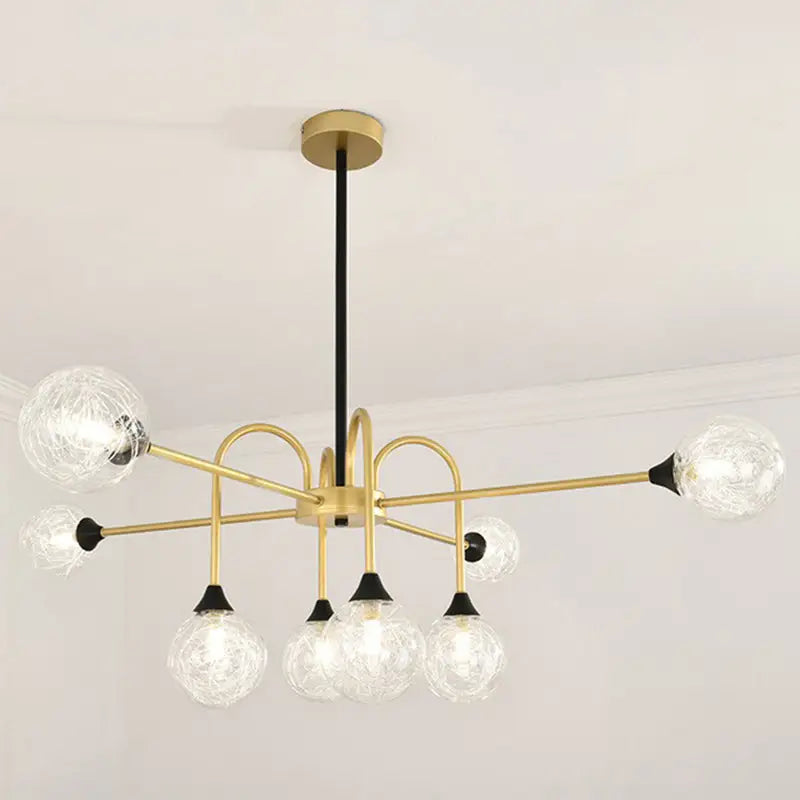 Gold-toned DecorBites Modo 6-head chandelier with clear textured glass globes and black accents for dining room lighting