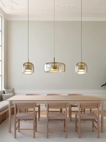 DecorBites™ Moroccan amber modern nordic pendant light features clear glass and brass accents above wooden table