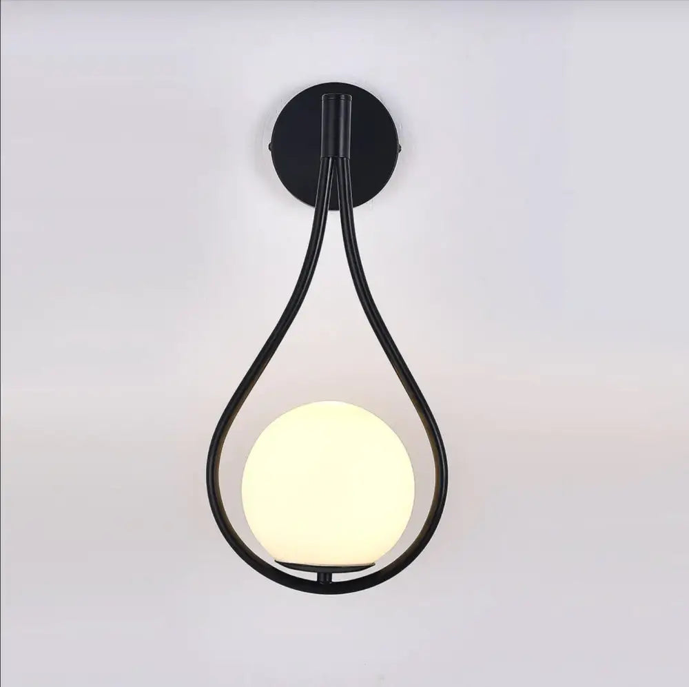 Black metal wall lamp with teardrop frame and illuminated frosted globe in decorbites™ moroccan gold modern nordic wall lamp
