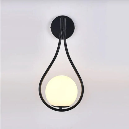 Black metal wall lamp with teardrop frame and illuminated frosted globe in decorbites™ moroccan gold modern nordic wall lamp