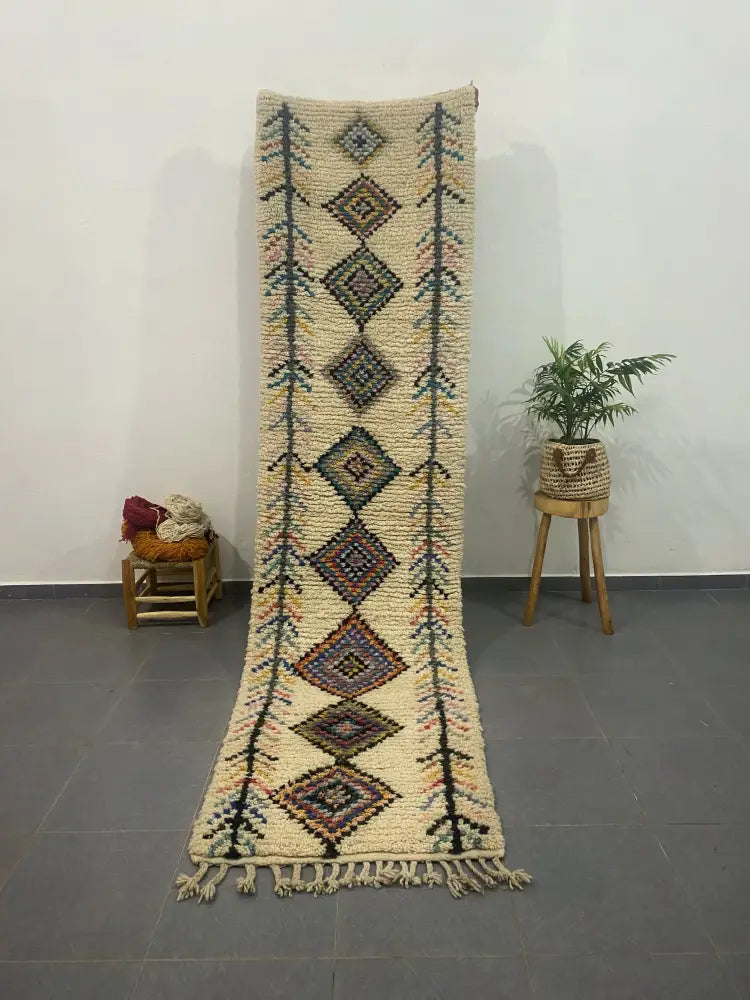 Beige moroccan handmade azilal rug with geometric diamond and vertical line patterns in muted earth tones and fringed edge