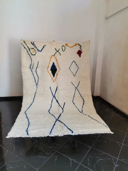 Cream-colored moroccan handmade azilal berber carpet with navy, mustard, and red geometric patterns supporting sustainable practices