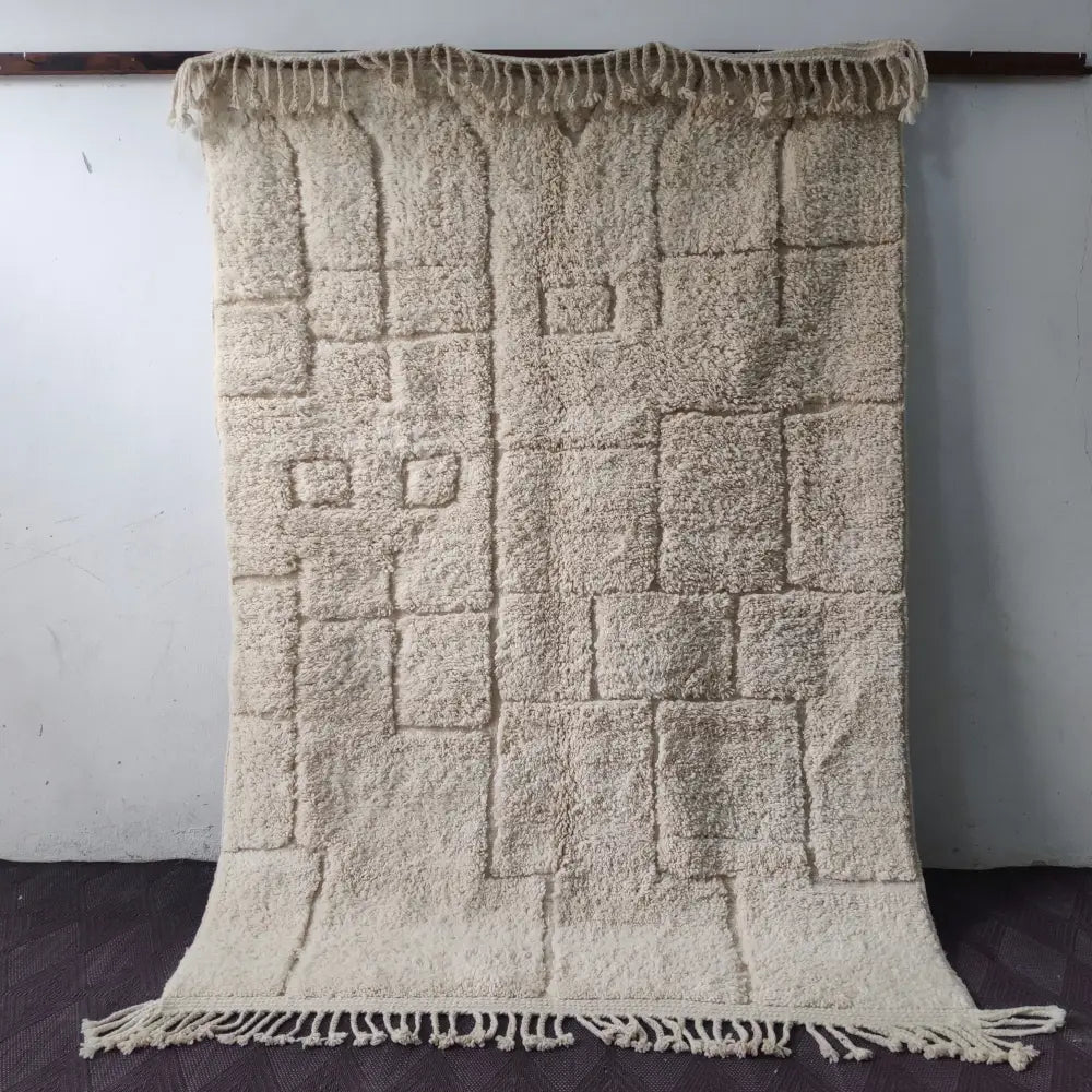 Cream-colored plush moroccan handmade beni ouarain rug with textured geometric pattern and fringed edges 2.5m x 1.5m