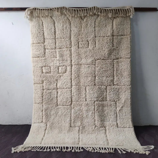 Cream-colored plush moroccan handmade beni ouarain rug with textured geometric pattern and fringed edges 2.5m x 1.5m