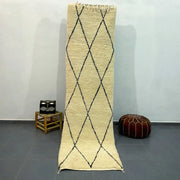 Cream-colored moroccan handmade beni ouarain rug with black geometric diamond patterns and fringed edges 2.8m x 0.7m