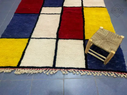 Vibrant moroccan handmade beni ouarain wool rug with geometric red blue yellow and cream squares bordered in black