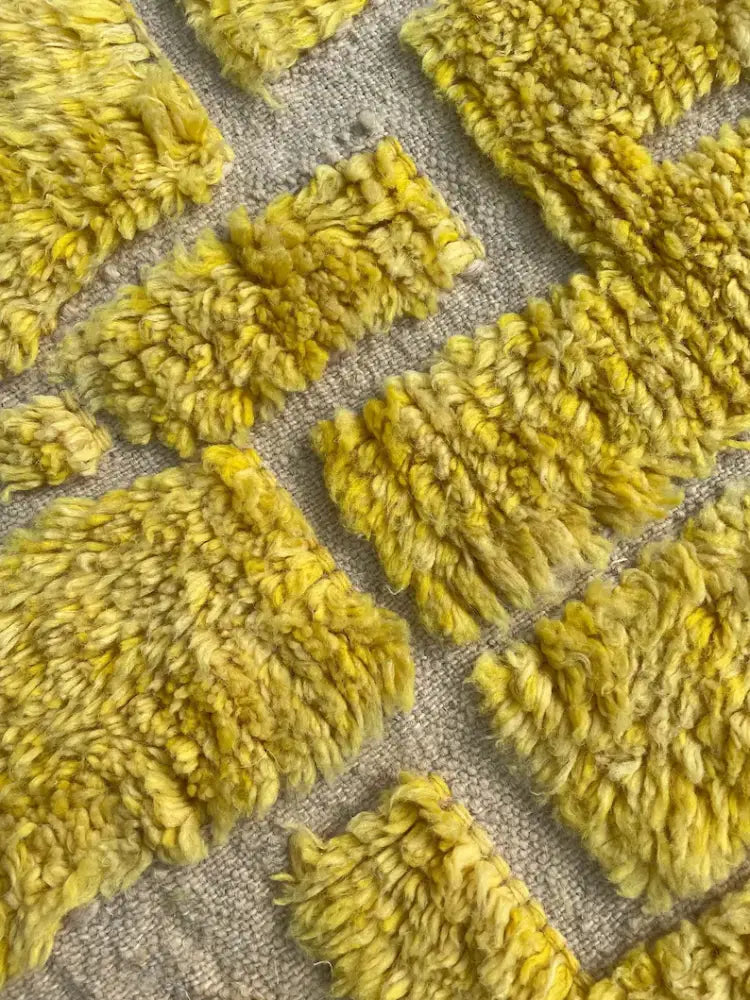 Decorbites™ moroccan handmade beni ouarain rug with vibrant yellow plush tufts in geometric pattern on neutral fabric base