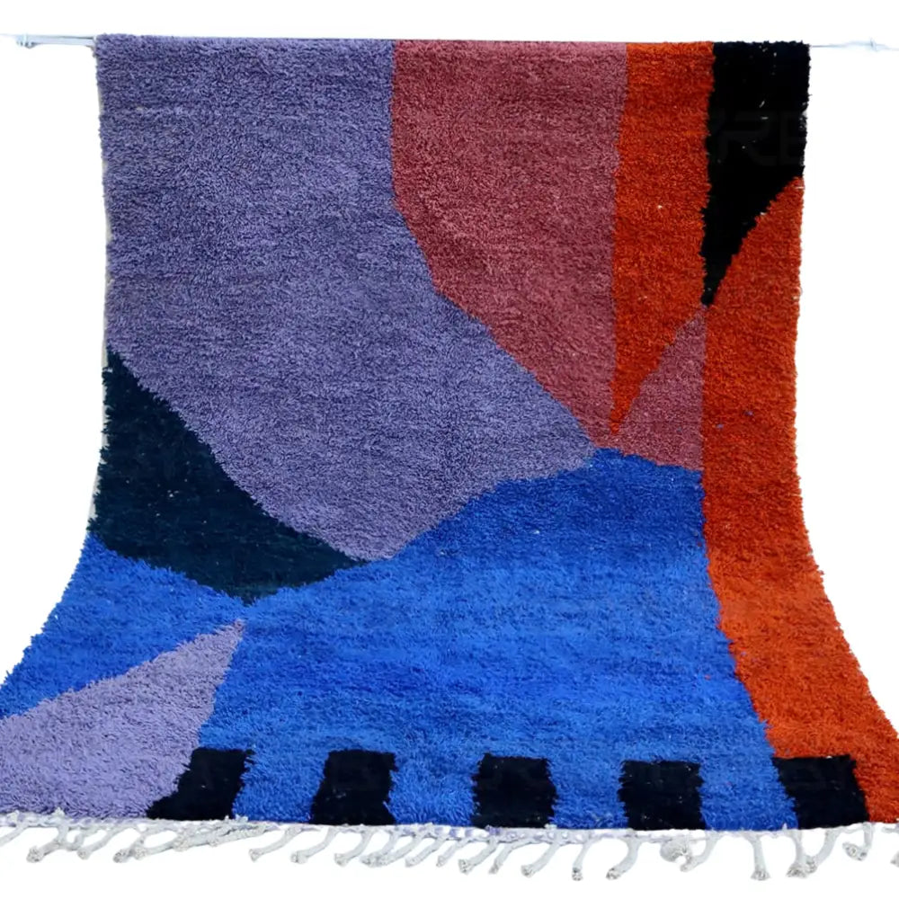 A plush moroccan handmade beni ouarain rug with geometric patterns in purple red-orange deep blue and black wool