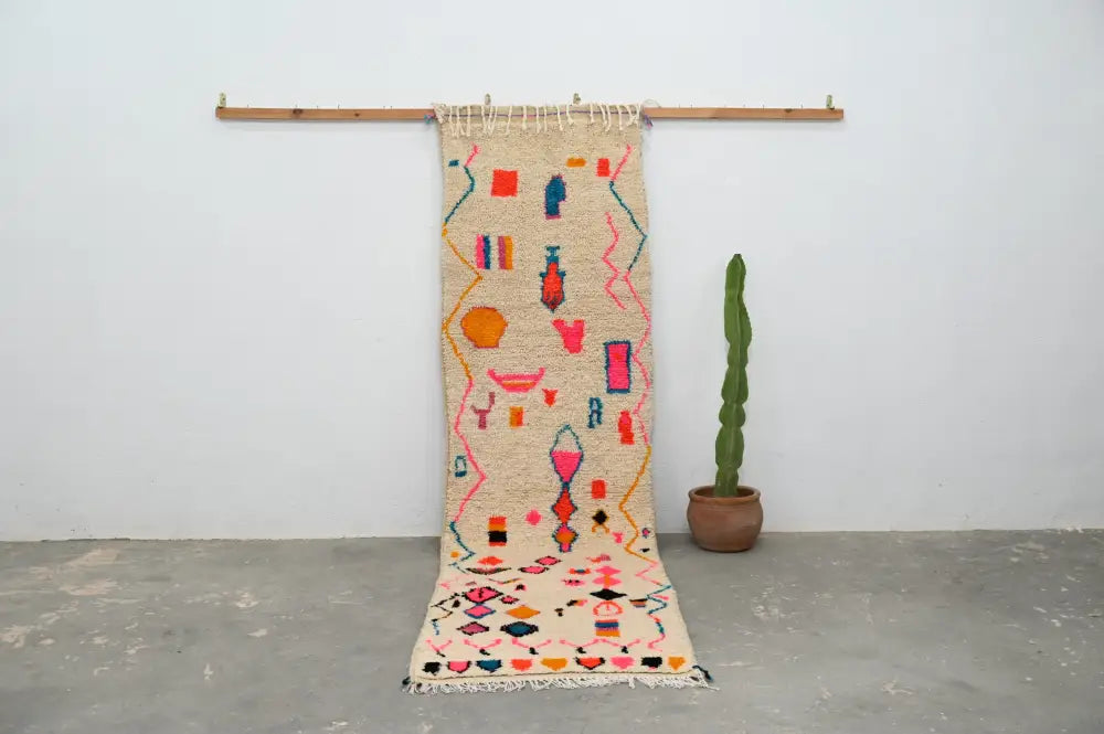 A vibrant moroccan handmade azilal hallway rug with cream base and colorful geometric patterns by DecorBites™
