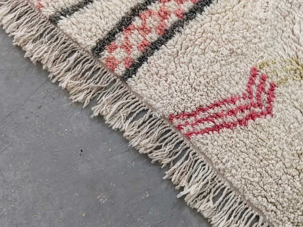Cream-colored moroccan handmade traditional azilal rug with fluffy texture and red dark gray geometric patterns