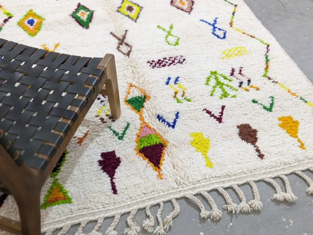 White moroccan handmade traditional azilal rug with colorful geometric patterns and fringed edge by decorbites